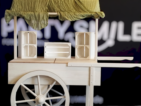 Candybar Holzwagen mit Lautsprechern und grüner Abdeckung, Hintergrund mit Schriftzug.