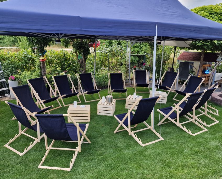 Sitzgelegenheiten & Tische Stuhlkreis mit 16 Liegestühlen unter einem Pavillon auf einer grünen Wiese.