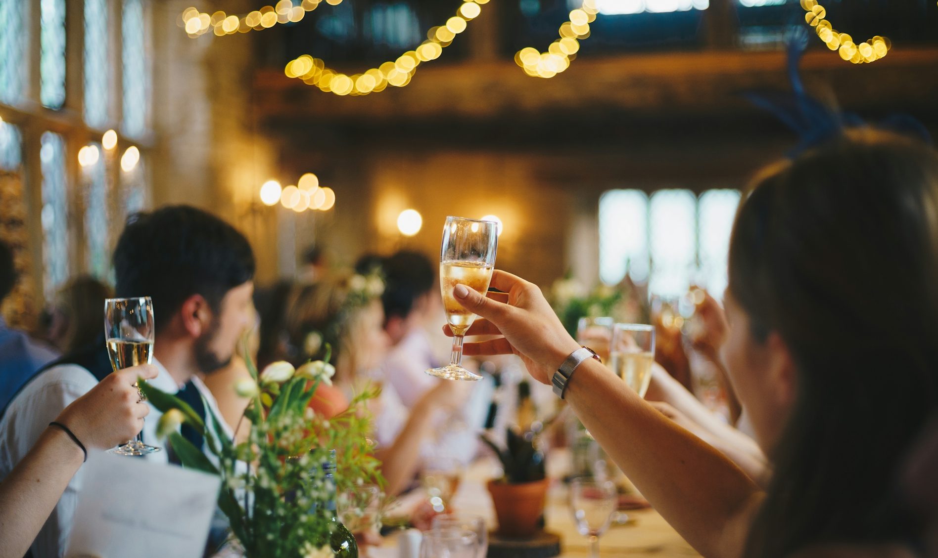 Eventverleih Feierliche Veranstaltung mit Gästen, die Gläser heben und festlich dekoriert.