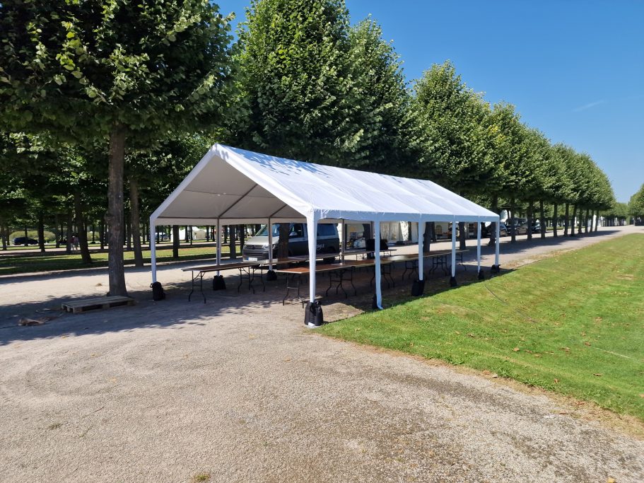 Partyzelte Große überdachte Fläche mit Bäumen und Rasen im Hintergrund.