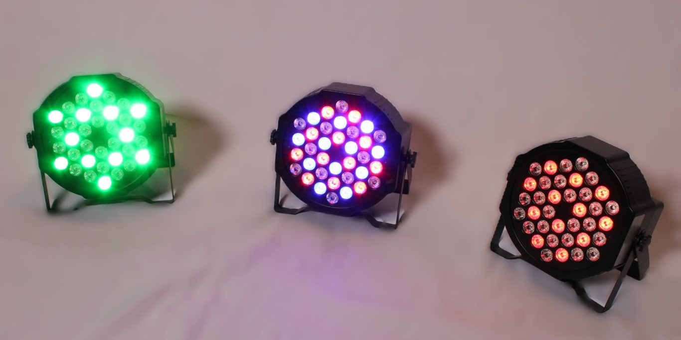 LED-Scheinwerfer Drei LED-Scheinwerfer in Grün, Lila und Rot auf einer weißen Oberfläche.